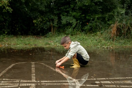 Child Playing in a Puddle Outdoors