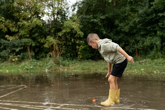 Child Playing in a Puddle Outdoors