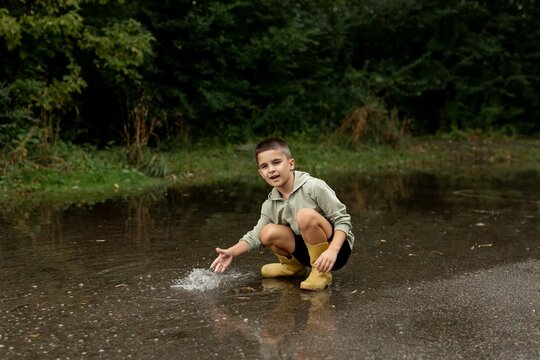 Child Playing in a Puddle Outdoors