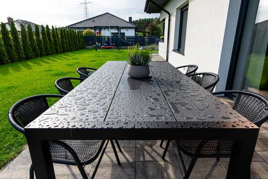 Garden table with water drops on outdoor patio