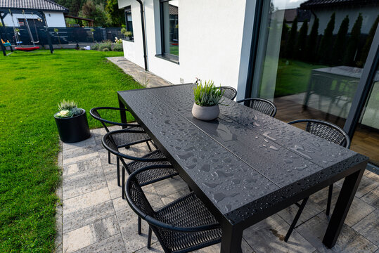 Modern garden table with water drops on outdoor patio