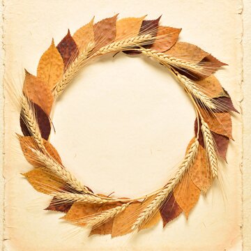 Decorative circular frame made of dried autumn leaves and golden wheat stalks on textured surface