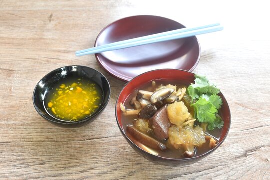 braised fish maw with bamboo shoot and pork blood with chicken meat in red gravy soup on bowl dipping spicy sour chili sauce