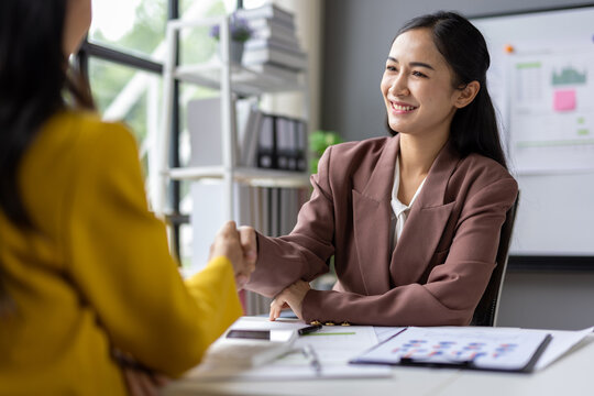 Two businesswoman shaking hands during a meeting in the office.