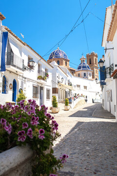 Altea old town street with church domes and flowers
