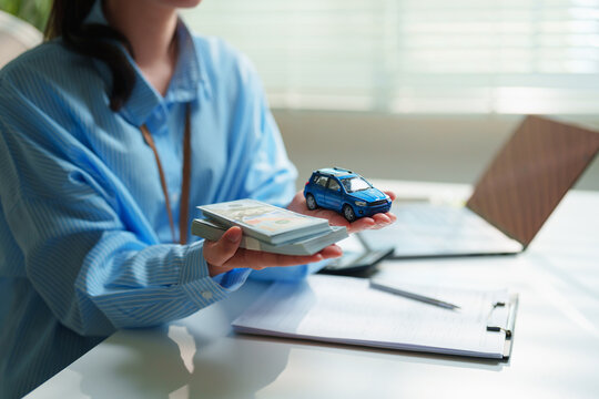 Insurance agent evaluating vehicle replacement value and cash settlement payouts at a modern corporate desk, comprehensive auto insurance, claims processing, and deductible management