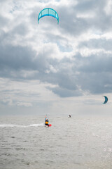 Man kiteboarding on the sea while controlling a kite. Kitesurfing, water and extreme sport, active recreation, summer activities, outdoor adventure and an active lifestyle. © Александра Климчук