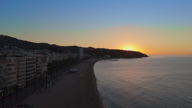 Aerial view taken from a drone of the coast of Lloret de Mar, Costa Brava, Spain, early in the morning at sunrise - the sea, beach and coastal hotels