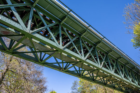 Green Steel Truss Bridge Seen from Below against a Blue Sky