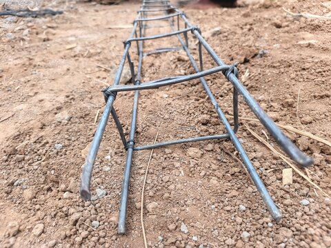 construction site of a construction site, Close-up view of a steel reinforcement bar framework arranged on the ground at a construction site, showing interconnected metal bars prepared for concrete fo