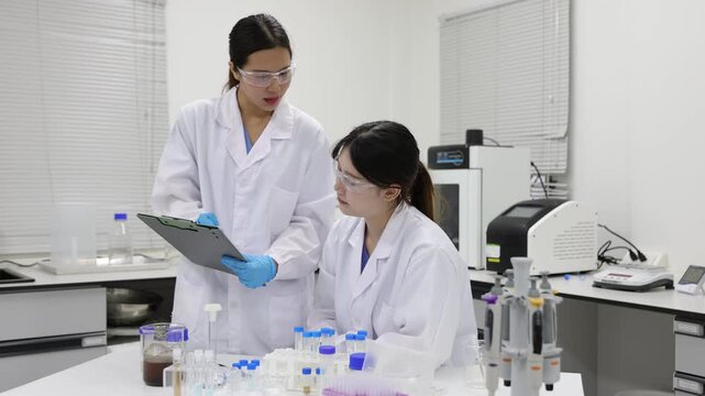 Stressed scientist failing experiment in laboratory. Frustrated female scientist feeling disappointed after a failed experiment in the lab. Her colleague tries to help, but she is stressed.