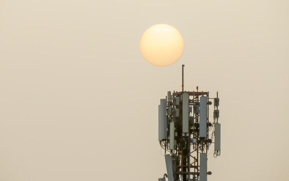 El sol a trav&eacute;s del polvo en suspensi&oacute;n del S&aacute;hara sobre Madrid, Espa&ntilde;a. Sol junto a una torre de telecomunicaciones. Fen&oacute;meno meteorol&oacute;gico conocido como calima sobre Madrid el 27 Feb 2020.