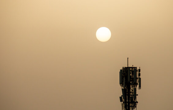 El sol a trav&eacute;s del polvo en suspensi&oacute;n del S&aacute;hara sobre Madrid, Espa&ntilde;a. Sol junto a una torre de telecomunicaciones. Fen&oacute;meno meteorol&oacute;gico conocido como calima sobre Madrid el 27 Feb 2020.