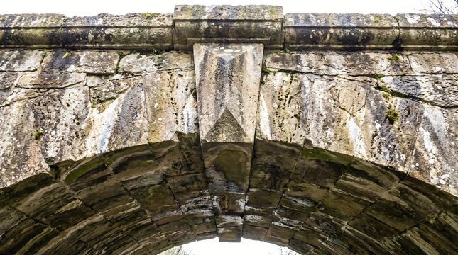 Keystone Concept, Central Wedge Stone Locking An Old Arch Bridge Together
