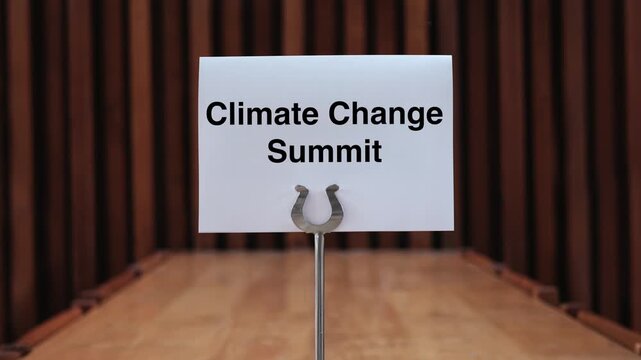 Push-in Shot On A Climate Change Summit Card Displayed On Wooden Conference Table