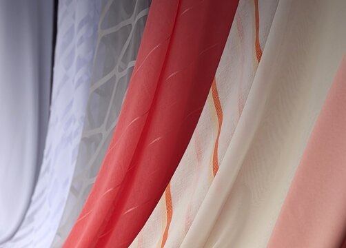 Selection of light sheer curtain fabrics hanging in diagonal composition