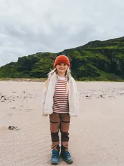 Cute girl tourist standing on remote beach in Norway family travel outdoor adventure hiking vacation active lifestyle, exploration nature eco tourism scandinavian destination childhood candid emotions © EVERST