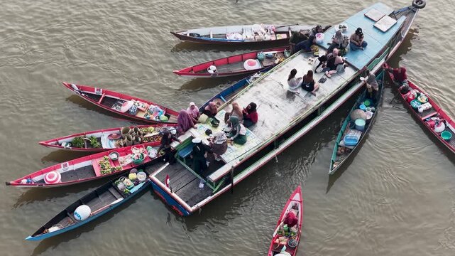 Vendors sell fresh produce and goods from wooden boats on the river at Lok Baintan Floating Market
