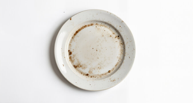 One dirty plate on white background, top view. Space for text
