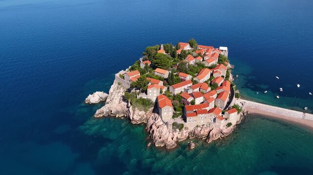 Aerial view of the island of St. Stefan on the Adriatic coast of Montenegro in Mediterranean Sea, showing the coastline and architecture. It is an island resort and popular summer vacation destination