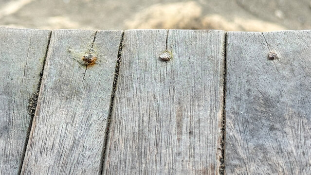 Close-up of weathered gray wood planks with rusty vintage nails and natural grain texture