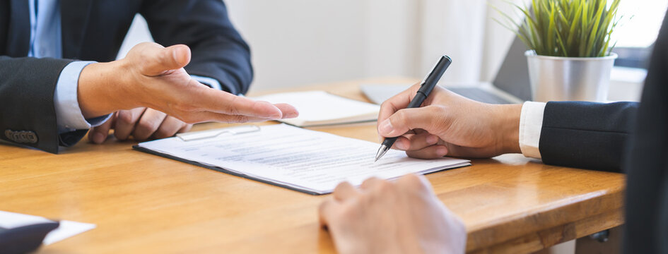 Business finance concept, teamwork and partnership asian businessman customer and salesman discussing client, hand sign sales contract with document at desk office. Lawyers working together at meeting