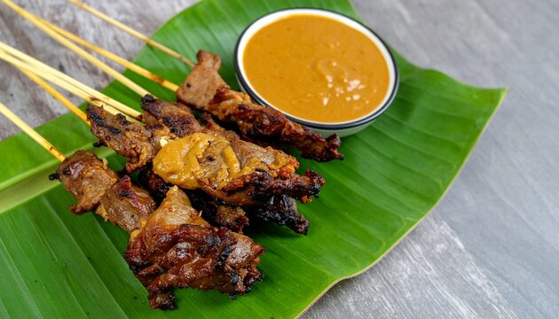 Grilled Beef Satay Skewers Served With Creamy Peanut Sauce on Banana Leaf