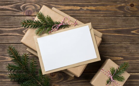 Christmas gift boxes with blank card on wooden background