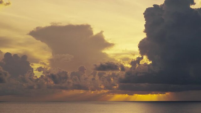 Dramatic Storm Clouds with Crepuscular Sun Rays Over Ocean Horizon