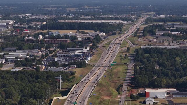 Aerial of suburban highway 65 interchange in Springfield Missouri in summer with multiple lanes of traffic and large commercial and industrial buildings