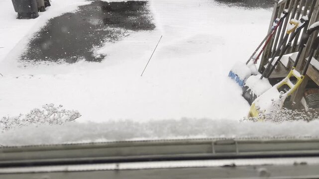 looking through window at snow falling on backyard in February in New Jersey