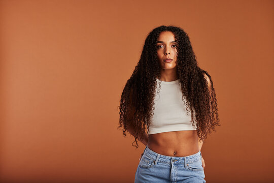Young black woman posing in front of an orange background