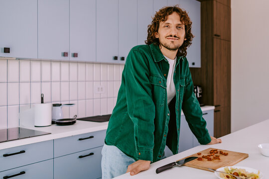 Confident Young Man Cooking in Modern Home Kitchen Preparing Meal Prep and Healthy Lunch