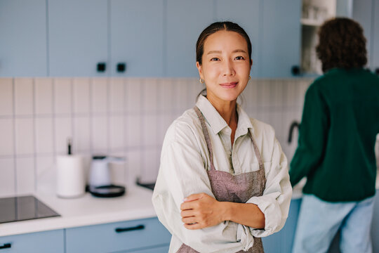 Confident Female Entrepreneur Standing in Modern Home Kitchen Wearing Apron, Small Business Owner Portrait