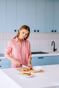 Smiling Woman Preparing Food in Modern Home Kitchen &mdash; Casual Lifestyle and Healthy Cooking
