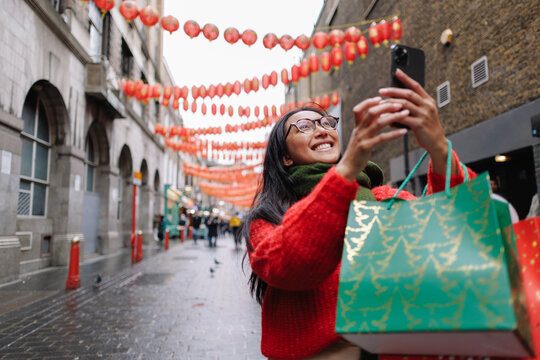 Young woman enjoying Christmas shopping in London Chinatown
