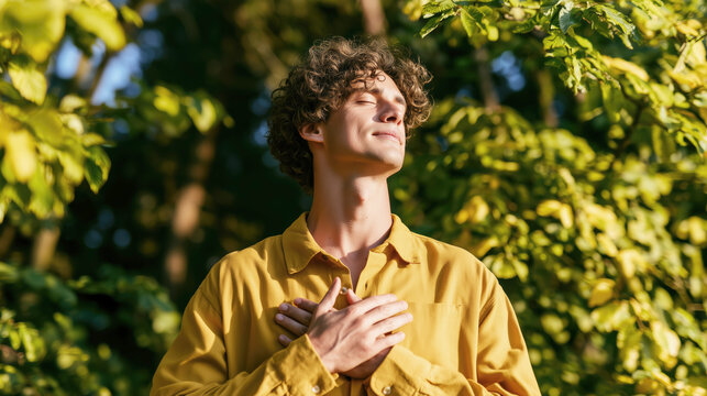 Young man enjoying nature moment with closed eyes and peaceful expression