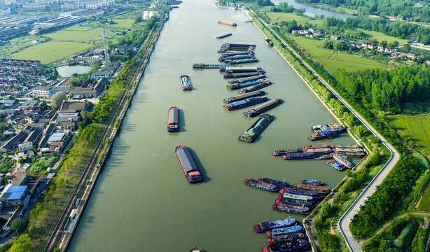 multiple cargo barges navigating busy inland waterway