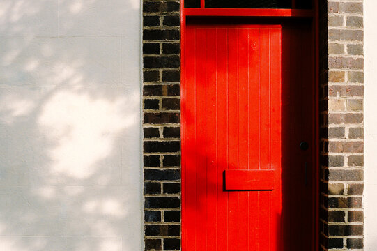 Bright Red Door Framed by Rustic Brick Wall