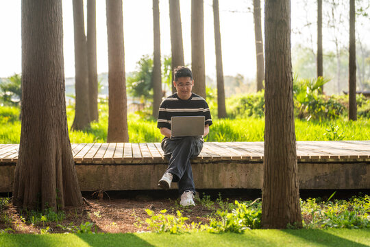 Young man working on laptop outdoors