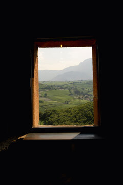Adige Valley vineyards framed by castle window in South Tyrol