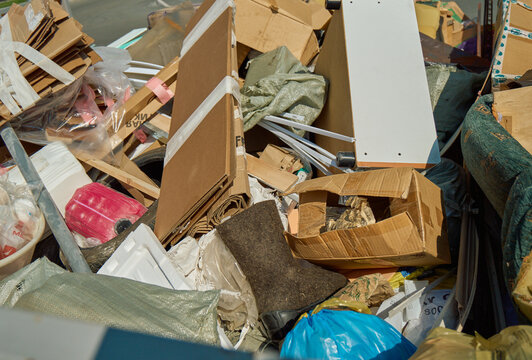 Detailed view of tied bundles of discarded cardboard packaging boxes and paper materials piled up for waste disposal at an urban collection area