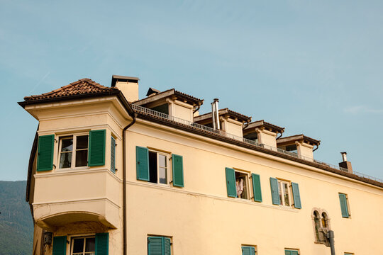 Italian town building with green shutters in summer light