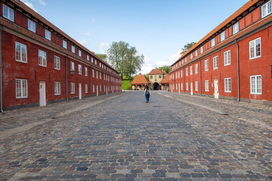 Woman walking cobblestone street in Kastellet, Copenhagen