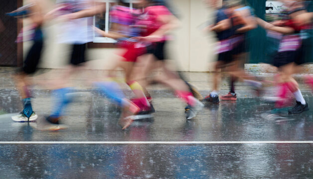 Motion Blur Marathon Runners on Rainy City Street