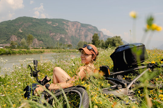 Woman resting in wildflowers during summer bikepacking trip