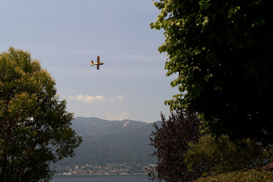 Firefighter Plane Flies Over the Lake Near Mountains on a Clear Day