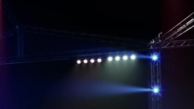 Bright colored lights shine on a stage designed for a performance. Shadows and beams are visible from different light sources. The setup is ready for an event indoors.