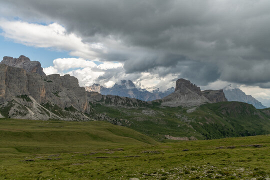 Mondeval, Italy. Dramatic Dolomites mountain landscape with alpine meadows, rugged limestone cliffs and storm clouds