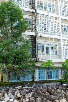 Ancien b&acirc;timent r&eacute;sidentiel tropical avec fa&ccedil;ade blanche et claustras en b&eacute;ton